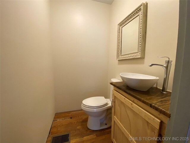 1501 E Okmulgee St, Muskogee, OK 74403 - bathroom featuring vanity, wood finished floors, and toilet
