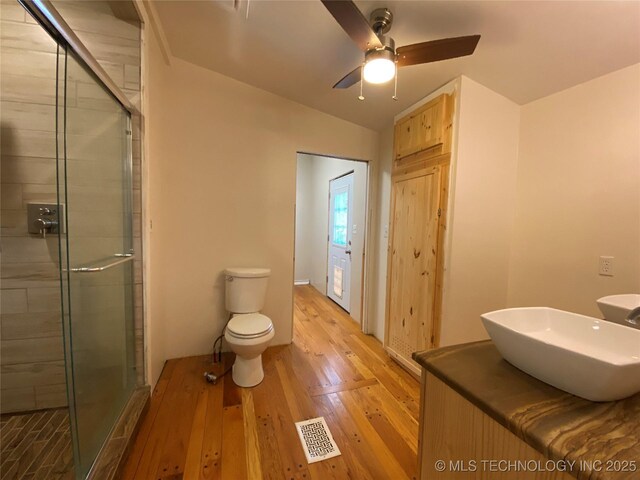 1501 E Okmulgee St, Muskogee, OK 74403 - bathroom with a stall shower, toilet, wood finished floors, ceiling fan, and vaulted ceiling