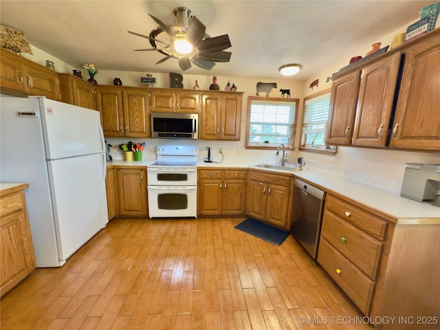5401 N 435th Rd, Adair, OK 74330 - kitchen with stainless steel appliances, a sink, brown cabinets, a ceiling fan, and light wood finished floors