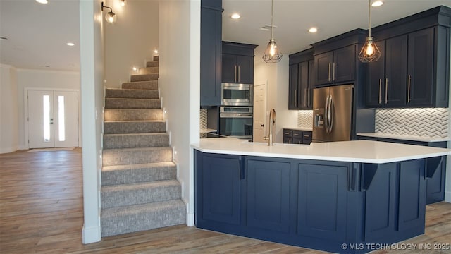 1223 Buckingham, Ardmore, OK 73401 - kitchen featuring stainless steel appliances, a peninsula, a sink, decorative backsplash, and light wood-style flooring