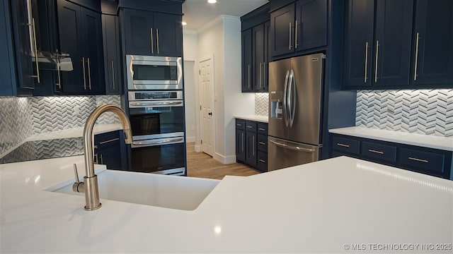 1223 Buckingham, Ardmore, OK 73401 - kitchen featuring appliances with stainless steel finishes, light countertops, tasteful backsplash, recessed lighting, and ornamental molding