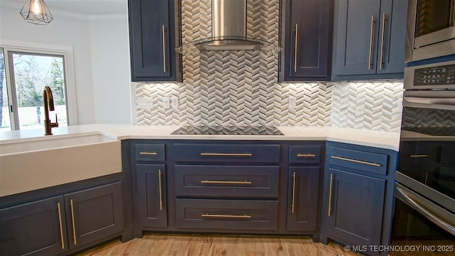 1223 Buckingham, Ardmore, OK 73401 - kitchen featuring wall chimney range hood, a sink, appliances with stainless steel finishes, crown molding, and light countertops