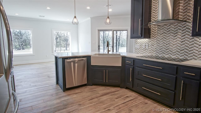 1223 Buckingham, Ardmore, OK 73401 - kitchen with stainless steel appliances, wall chimney range hood, a sink, light countertops, and tasteful backsplash
