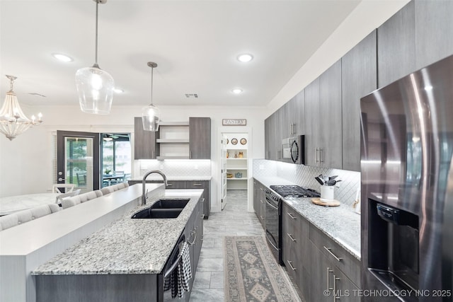 2621 S Catalayah Ln, Claremore, OK 74019 - kitchen featuring stainless steel appliances, a sink, open shelves, backsplash, and an island with sink