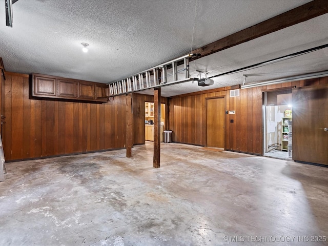 1800 SE Polaris Dr, Bartlesville, OK 74006 - garage featuring a garage door opener and wooden walls
