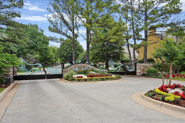 9926 S 79th E Ave, Tulsa, OK 74133 - view of concrete road featuring curbs, a gated entry, and a gate