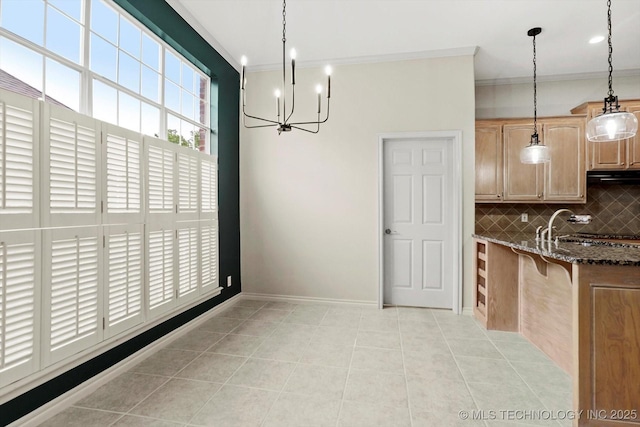 9926 S 79th E Ave, Tulsa, OK 74133 - unfurnished dining area with crown molding, a chandelier, light tile patterned floors, a sink, and baseboards