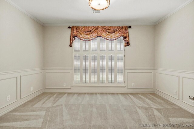 9926 S 79th E Ave, Tulsa, OK 74133 - spare room featuring a decorative wall, carpet floors, crown molding, and a wainscoted wall