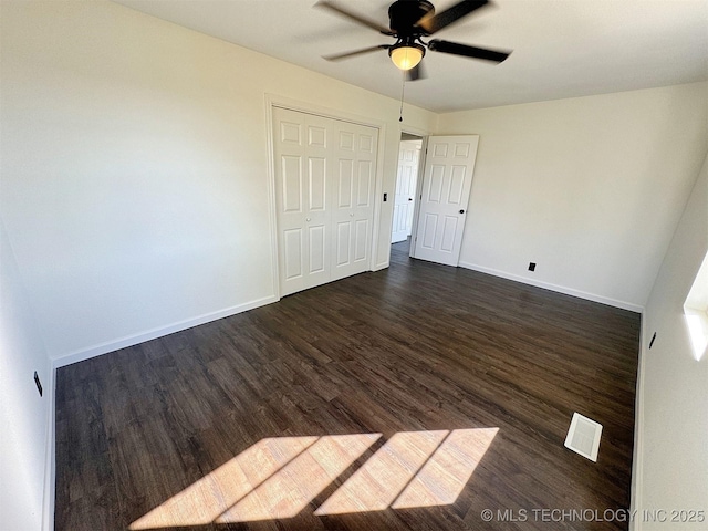 26037 S 520th Rd, Park Hill, OK 74451 - unfurnished bedroom with dark wood-style flooring, baseboards, a closet, and a ceiling fan