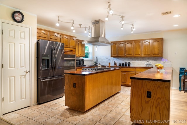7803 N 71st E Ave, Owasso, OK 74055 - kitchen featuring stainless steel appliances, island range hood, brown cabinetry, and a kitchen island