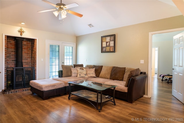 7803 N 71st E Ave, Owasso, OK 74055 - living room featuring vaulted ceiling, a ceiling fan, wood finished floors, and a wood stove