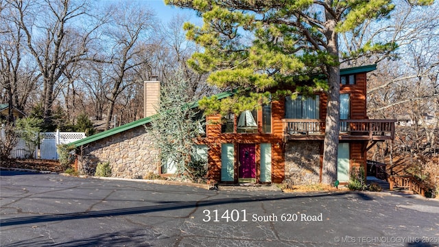31401 S 620th Rd, Grove, OK 74344 - view of front of property with stone siding, a chimney, and a balcony