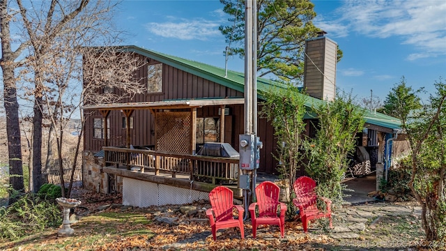 31401 S 620th Rd, Grove, OK 74344 - rear view of house with board and batten siding, a chimney, and a deck