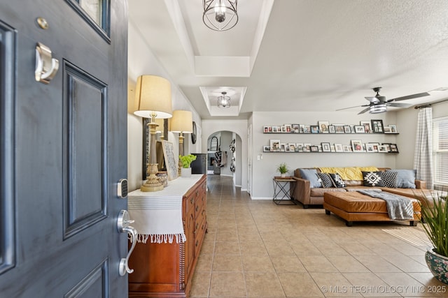14201 E 101st St, Owasso, OK 74055 - entryway with arched walkways, light tile patterned floors, a ceiling fan, and baseboards