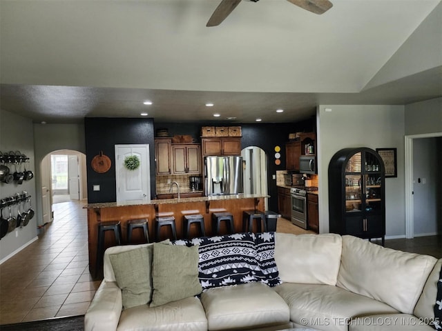 14201 E 101st St, Owasso, OK 74055 - living area with arched walkways, a ceiling fan, light tile patterned floors, recessed lighting, and baseboards
