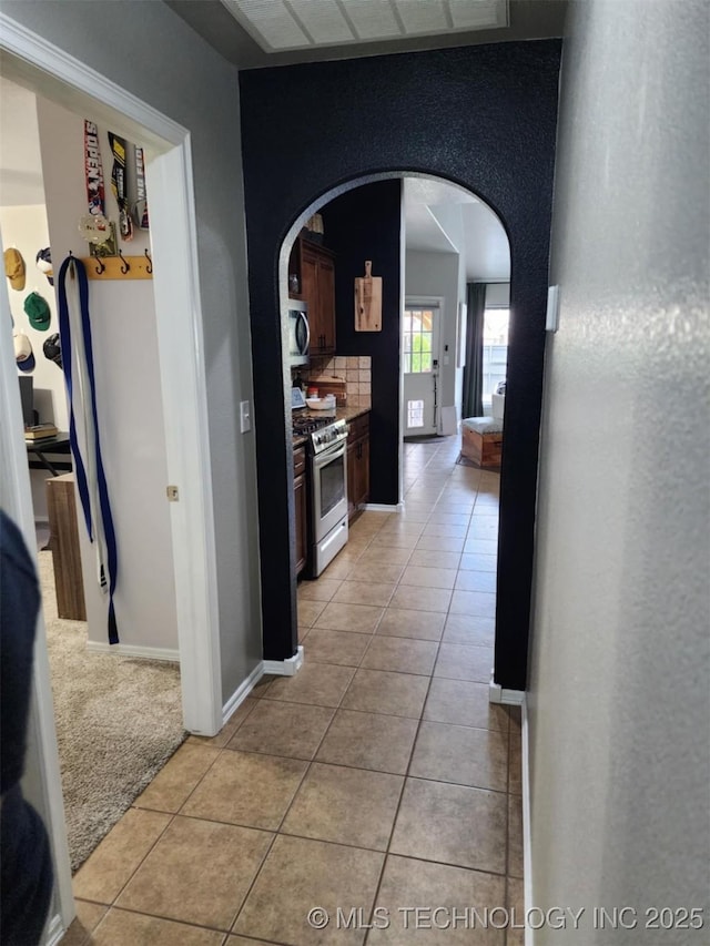 14201 E 101st St, Owasso, OK 74055 - corridor with arched walkways, light tile patterned floors, and baseboards