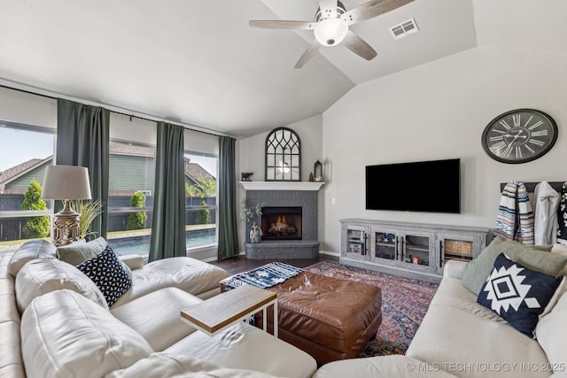 14201 E 101st St, Owasso, OK 74055 - living area with a lit fireplace, vaulted ceiling, and a ceiling fan