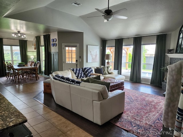 14201 E 101st St, Owasso, OK 74055 - living room with ceiling fan, lofted ceiling, tile patterned floors, and a tile fireplace