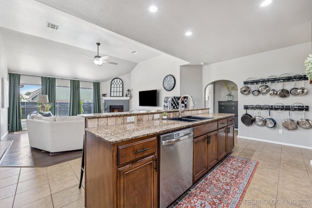 14201 E 101st St, Owasso, OK 74055 - kitchen with dishwasher, a sink, open floor plan, light tile patterned floors, and lofted ceiling