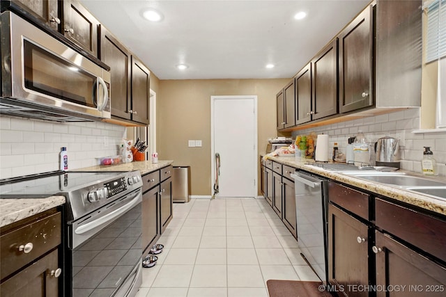 7630 E 54th Pl, Tulsa, OK 74145 - kitchen featuring appliances with stainless steel finishes, dark brown cabinetry, decorative backsplash, light tile patterned floors, and recessed lighting