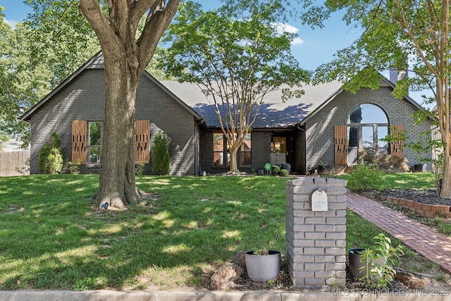 6717 E 99th St, Tulsa, OK 74133 - view of front of house featuring brick siding, a front yard, and a chimney