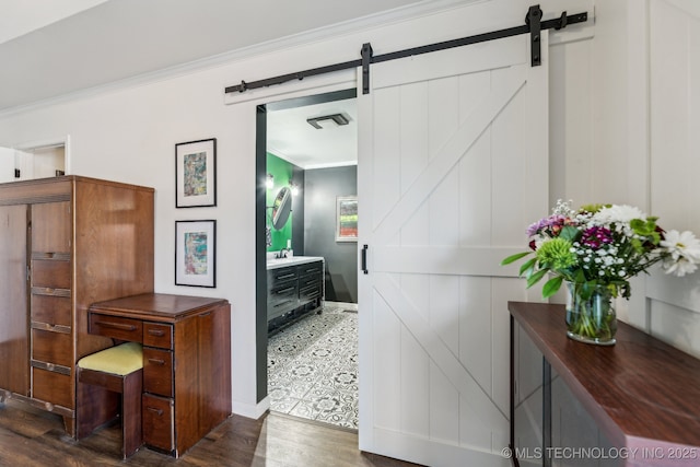 6717 E 99th St, Tulsa, OK 74133 - hall with a barn door, ornamental molding, wood finished floors, a sink, and baseboards