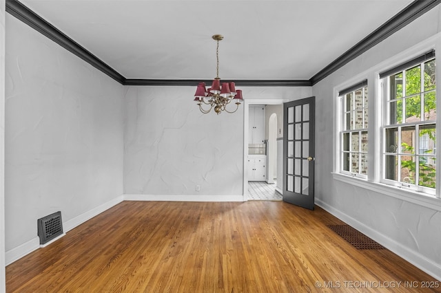2728 E 13th Pl, Tulsa, OK 74104 - unfurnished dining area with wood finished floors, healthy amount of natural light, a chandelier, ornamental molding, and baseboards