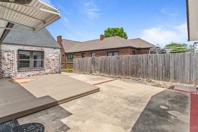 2728 E 13th Pl, Tulsa, OK 74104 - fenced backyard featuring a wooden deck and a patio area