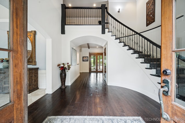 9914 S Garnett Rd, Broken Arrow, OK 74012 - entryway featuring arched walkways, hardwood / wood-style flooring, stairs, a high ceiling, and baseboards