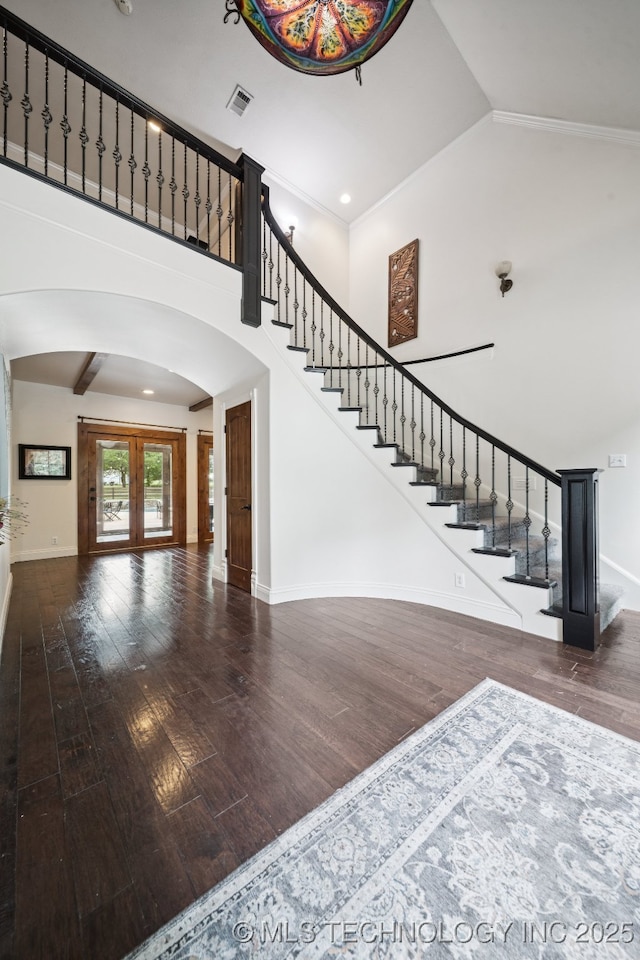 9914 S Garnett Rd, Broken Arrow, OK 74012 - staircase featuring arched walkways, wood finished floors, baseboards, and high vaulted ceiling