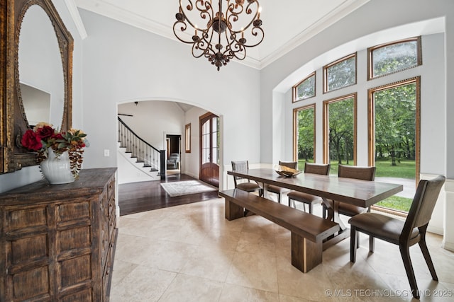 9914 S Garnett Rd, Broken Arrow, OK 74012 - dining area featuring arched walkways, ornamental molding, stairway, a towering ceiling, and a chandelier