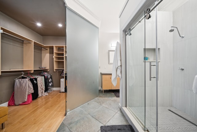 9914 S Garnett Rd, Broken Arrow, OK 74012 - bathroom featuring a shower stall, a walk in closet, recessed lighting, and wood finished floors