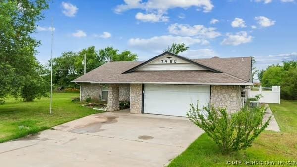 7450 N 117th E Ave, Owasso, OK 74055 - view of front of house with stone siding, concrete driveway, a front yard, and an attached garage