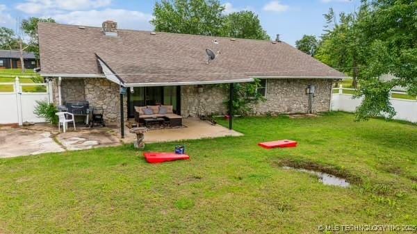 7450 N 117th E Ave, Owasso, OK 74055 - back of property featuring stone siding, a patio area, and an outdoor hangout area
