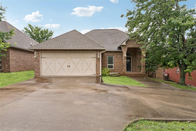2508 S 14th St, Mcalester, OK 74501 - view of front of home featuring concrete driveway, brick siding, a garage, and roof with shingles