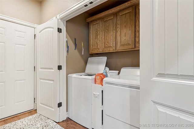 2508 S 14th St, Mcalester, OK 74501 - laundry area with cabinet space, washing machine and dryer, and wood finished floors