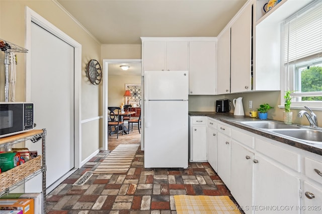 3508 E 30th St, Tulsa, OK 74114 - kitchen with freestanding refrigerator, black microwave, brick flooring, a sink, and ornamental molding
