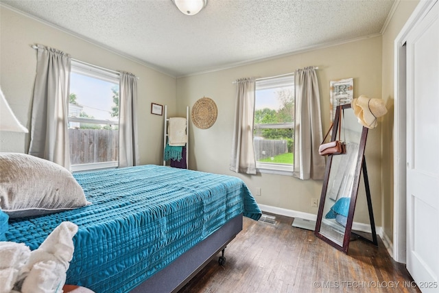 3508 E 30th St, Tulsa, OK 74114 - bedroom with wood finished floors, baseboards, crown molding, and a textured ceiling