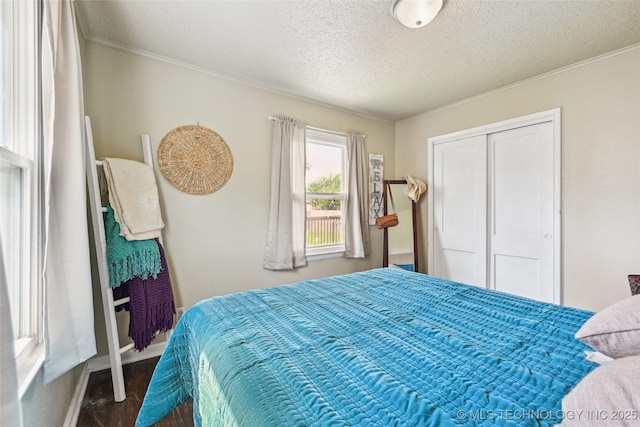 3508 E 30th St, Tulsa, OK 74114 - bedroom with crown molding, a textured ceiling, dark wood-style floors, a closet, and baseboards