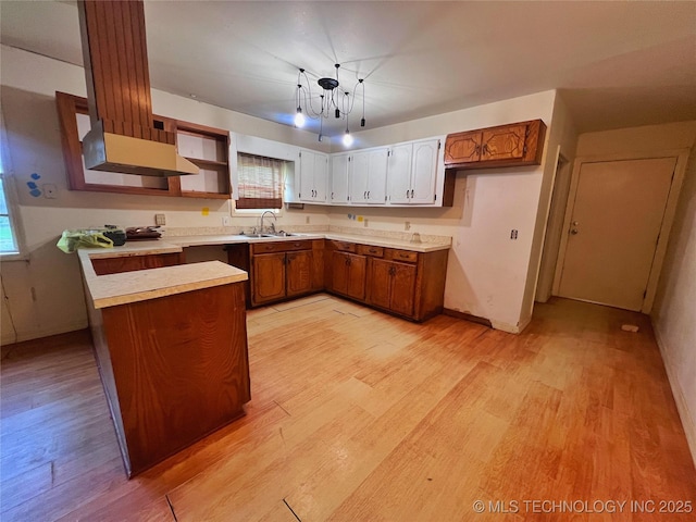 5006 S 449th Ave W, Jennings, OK 74038 - kitchen featuring a sink, light wood-style flooring, brown cabinets, and light countertops