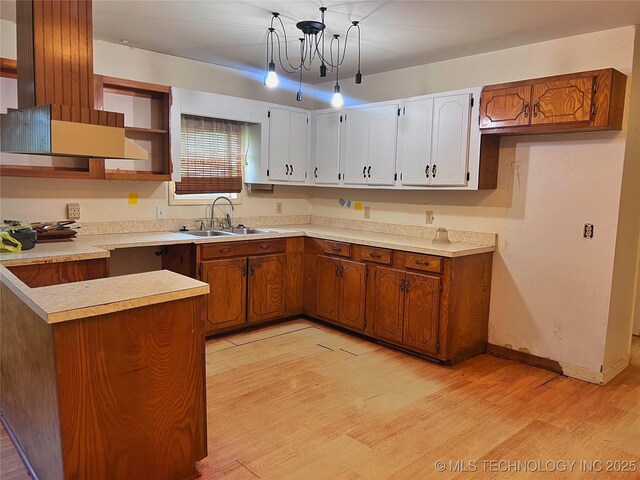5006 S 449th Ave W, Jennings, OK 74038 - kitchen featuring a sink, light wood finished floors, brown cabinets, decorative light fixtures, and open shelves