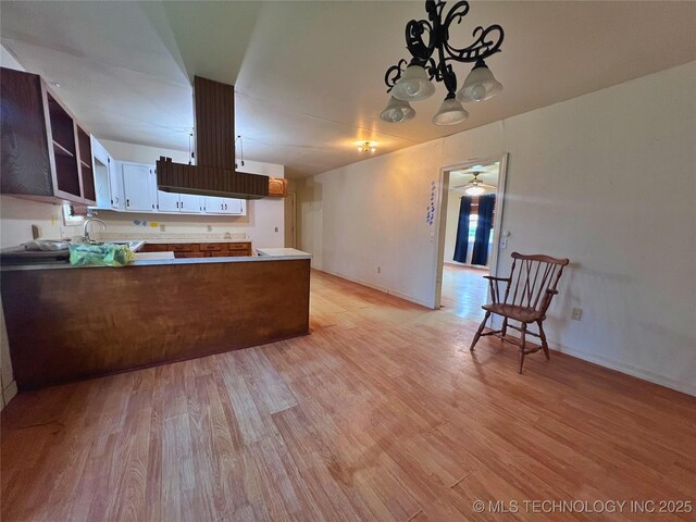 5006 S 449th Ave W, Jennings, OK 74038 - kitchen with a peninsula, light wood finished floors, a chandelier, and baseboards