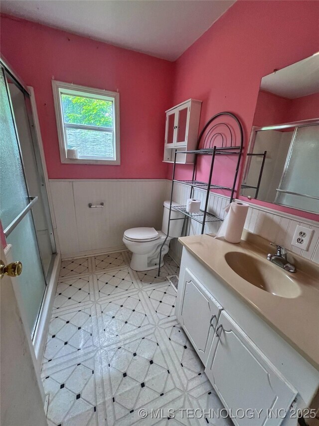 5006 S 449th Ave W, Jennings, OK 74038 - bathroom featuring a shower with door, wainscoting, vanity, toilet, and tile patterned floors