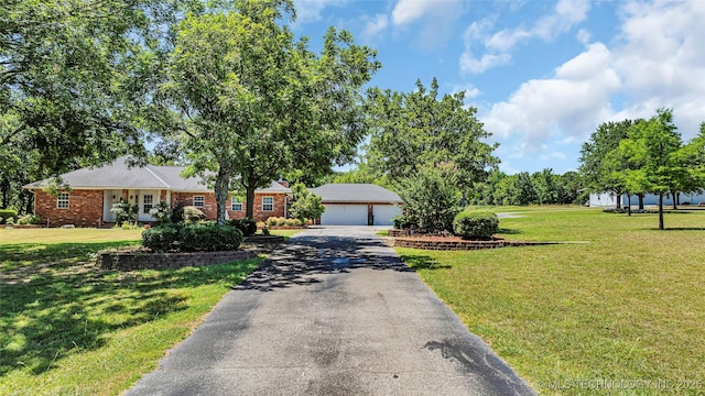 7023 Myall Rd, Lone Grove, OK 73443 - view of front of house featuring a garage, brick siding, a front yard, and an outbuilding