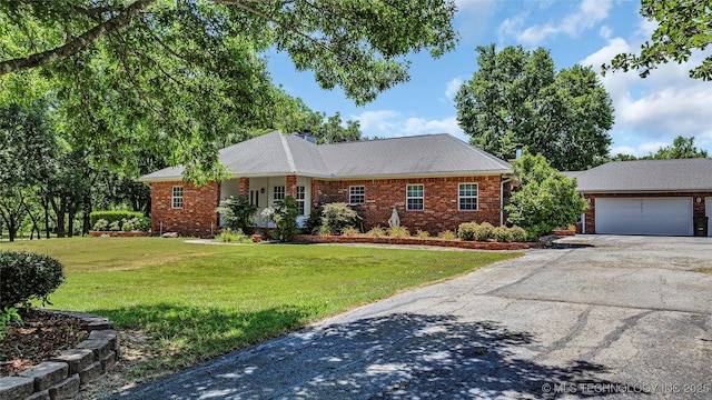 7023 Myall Rd, Lone Grove, OK 73443 - ranch-style home featuring brick siding, asphalt driveway, a front lawn, and a chimney
