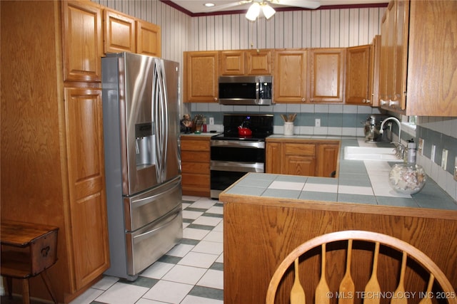 7023 Myall Rd, Lone Grove, OK 73443 - kitchen with appliances with stainless steel finishes, a sink, backsplash, tile counters, and crown molding