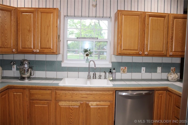 7023 Myall Rd, Lone Grove, OK 73443 - kitchen featuring dishwasher, a sink, tile counters, decorative backsplash, and brown cabinetry