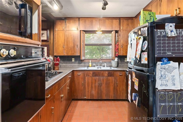 2506 Haskell Blvd, Muskogee, OK 74403 - kitchen featuring black appliances, brown cabinetry, a sink, and brick flooring