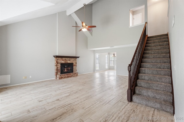 1802 S Fir Pl, Broken Arrow, OK 74012 - unfurnished living room with high vaulted ceiling, a ceiling fan, stairs, wood finished floors, and beam ceiling