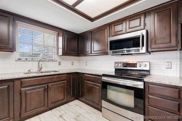 1802 S Fir Pl, Broken Arrow, OK 74012 - kitchen featuring appliances with stainless steel finishes, a sink, dark brown cabinets, and backsplash